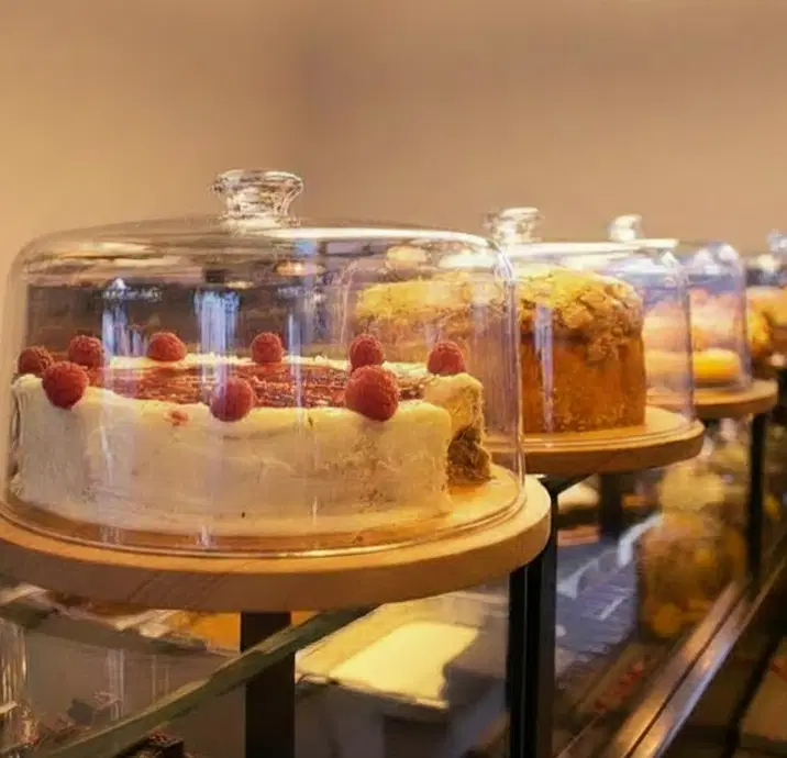 A selection or large homemade cakes under glass domes